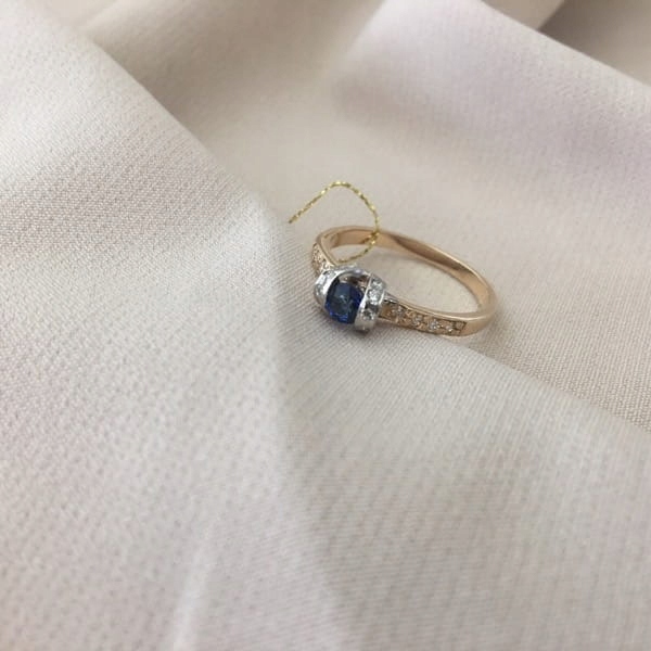 Zlatý prsteň s bielymi a žltými diamantmi a zafírom